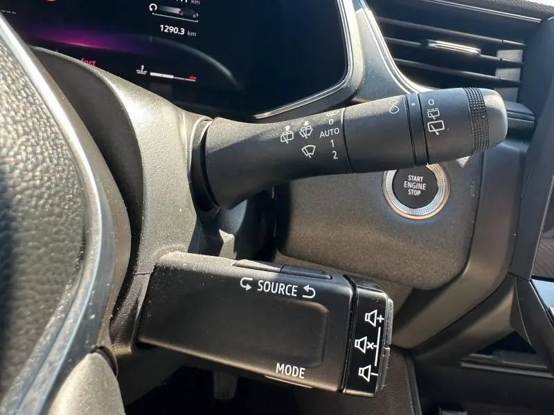 Gros plan intérieur sur la commande des essuie-glaces et bouton start/stop du Renault Captur gris Cassiopée métallisé/Noir Etoilé.