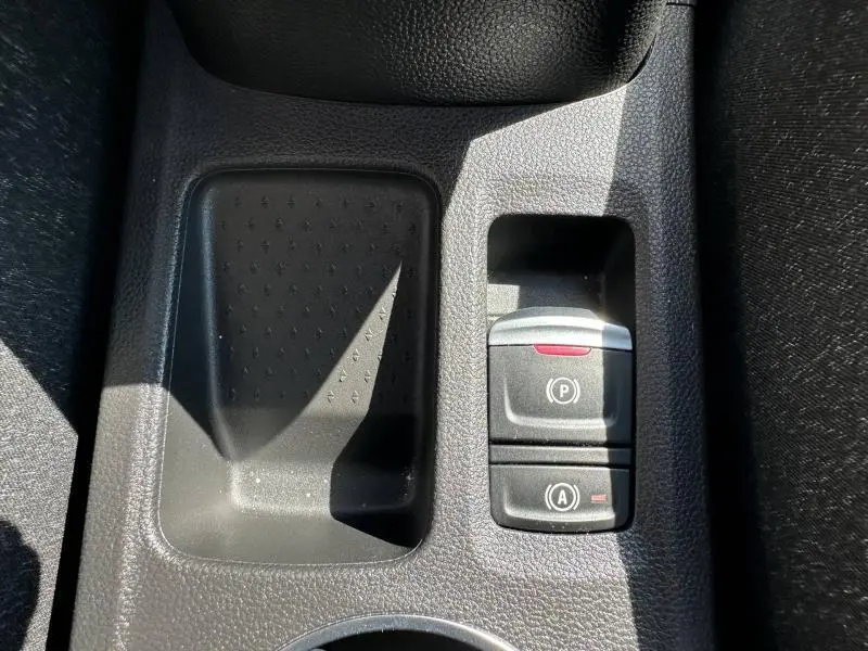 Gros plan sur la console centrale noire du Renault Captur 2025, avec bouton frein à main électrique et arrêt auto.