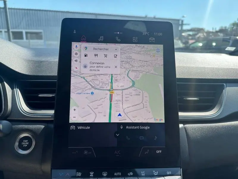 Vue intérieure centrée sur l'écran tactile du tableau de bord du Renault Captur gris Cassiopée, affichant la navigation GPS.