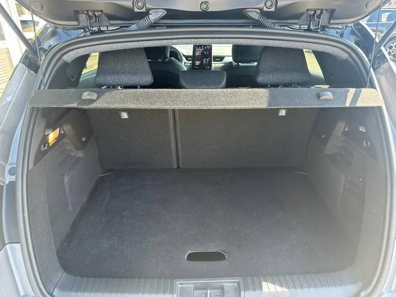 Coffre ouvert vu de l'arrière du Renault Captur gris Cassiopée métallisé avec banquette arrière et tablette cache-bagages.