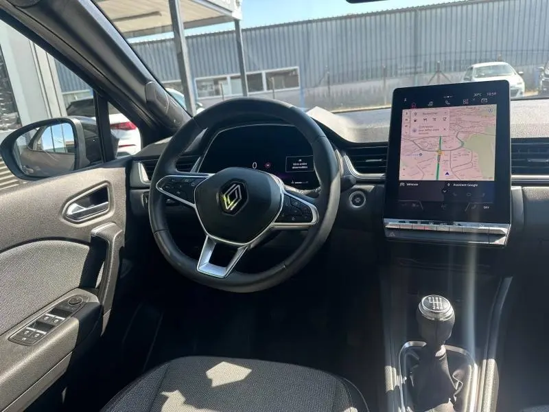 Intérieur du Renault Captur 2025 vu de face, volant multifonction, écran tactile vertical et levier de vitesses manuel.