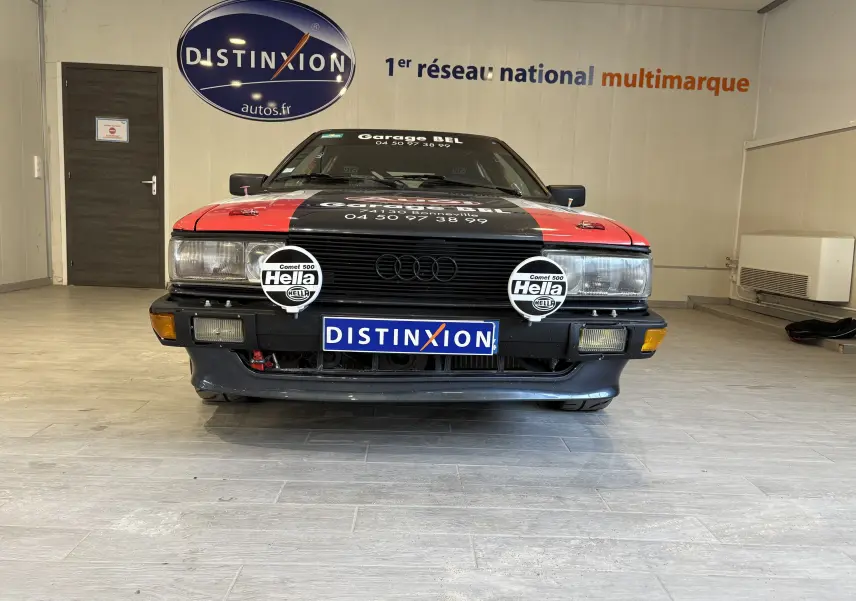 Audi Coupé GT 1983 noir vue 3/4 avant avec stickers rallye rouges et blancs, phares additionnels Hella, pneus semi-slicks.