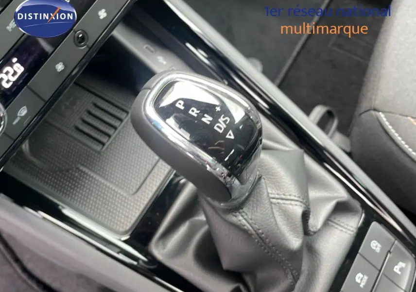 Gros plan sur le levier de vitesse automatique noir et chrome du Skoda Kamiq 2025, entouré de la console centrale brillante.
