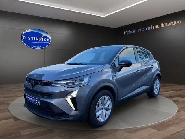 Renault Captur TCe 90 Evolution gris Cassiopée avec toit noir, vue 3/4 avant mettant en valeur la calandre et les feux LED.