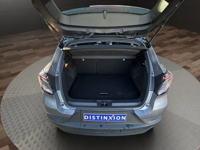 Vue arrière ouverte du coffre du Renault Captur gris Cassiopée avec toit noir, montrant l'espace de chargement vide.