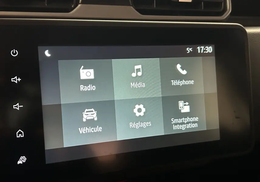 Écran tactile central du tableau de bord du Dacia Duster 2025 affichant les menus Radio, Média, Téléphone, Véhicule, Réglages et Smartphone Integration.