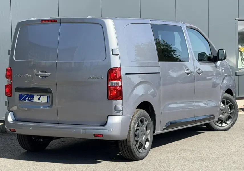 Vue 3/4 arrière droite du Citroën Jumpy gris Artense avec portes battantes arrière et jantes noires.