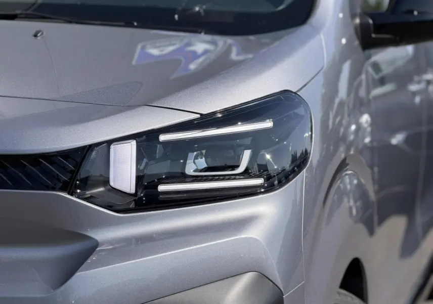 Gros plan sur le phare avant droit du Citroën Jumpy gris Artense, mettant en valeur son design LED moderne.