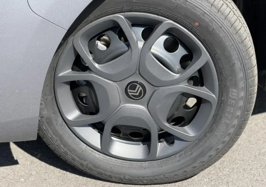 Gros plan sur la roue avant gauche avec jante tôle noire et enjoliveur du Citroën Jumpy gris Artense 2026.