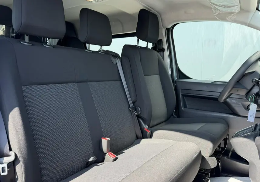 Vue intérieure côté droit montrant les sièges avant et banquette 3 places du Citroën Jumpy gris Artense.