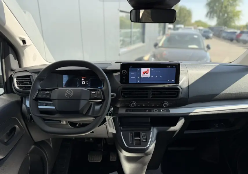 Vue intérieure avant du Citroën Jumpy gris Artense, tableau de bord avec écran tactile 10 pouces et volant multifonction.