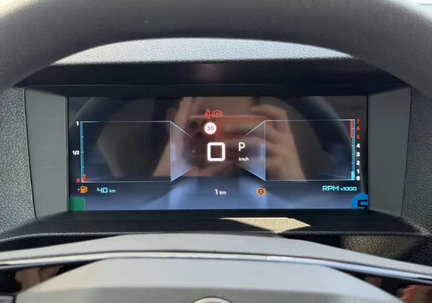 Vue rapprochée du tableau de bord numérique du Citroën Jumpy gris Artense, affichant la vitesse et les alertes.