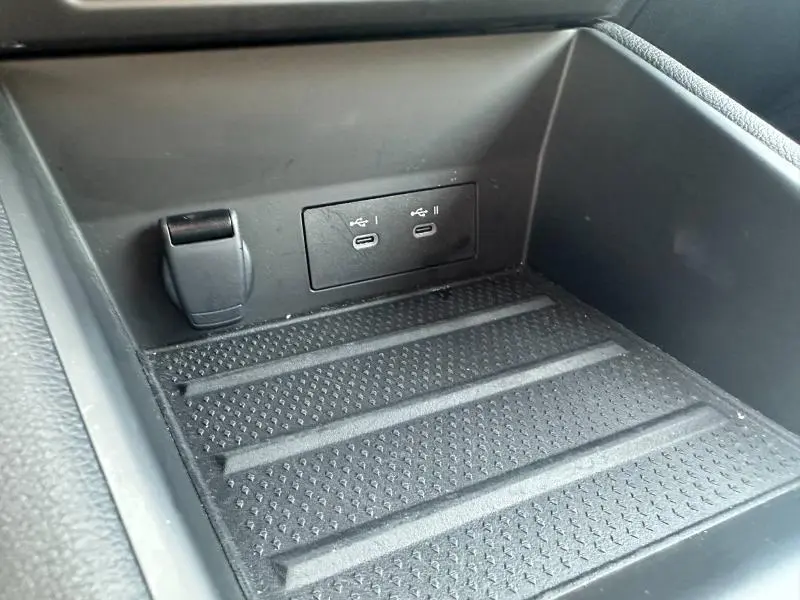 Gros plan sur la console centrale noire du Renault Symbioz 2025, montrant deux ports USB-C et une prise 12V.
