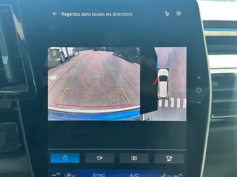 Écran tactile intérieur montrant la caméra de recul et vue à 360° du Renault Austral bleu Iron avec toit noir étoilé.