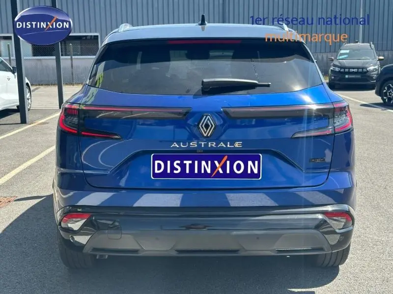 Vue arrière d'un Renault Austral bleu Iron avec toit noir étoilé, feux arrière LED et logo central visible.
