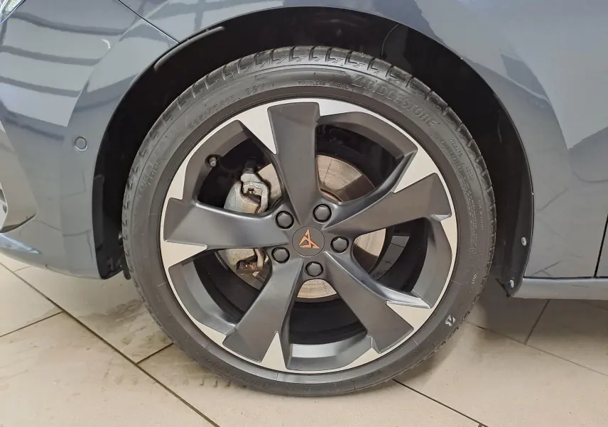 Gros plan sur la roue avant gauche de la CUPRA Leon 2023 en gris magnétique avec jante alliage bicolore distinctive.