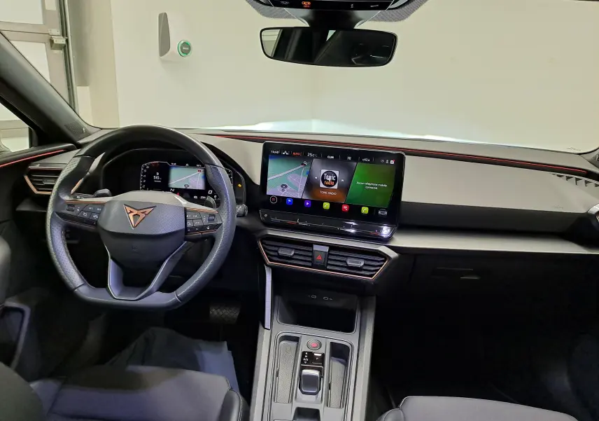 Vue intérieure avant de la CUPRA Leon 1.5 TSI 2023 avec tableau de bord numérique et écran tactile central.