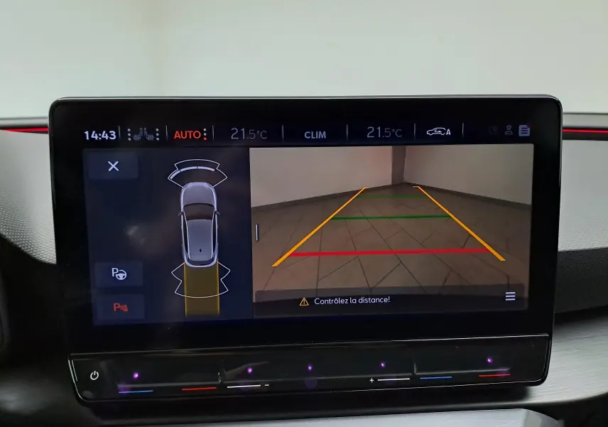 Écran multimédia de la CUPRA Leon 2023 montrant la caméra de recul avec lignes de guidage colorées.
