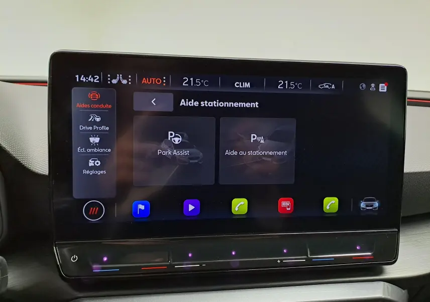 Écran tactile central de la CUPRA Leon 2023 affichant les aides à la conduite et la climatisation à 21,5°C.