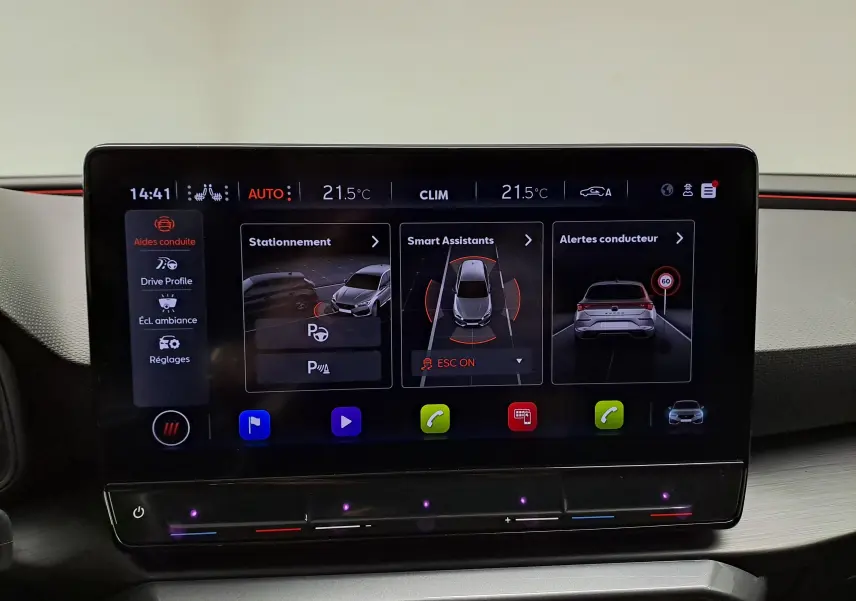 Écran tactile central du tableau de bord du CUPRA Leon 2023 affichant les aides à la conduite et la climatisation.