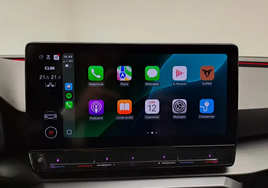 Écran tactile central du tableau de bord de la CUPRA Leon 2023 affichant des applications connectées, ambiance intérieure moderne.