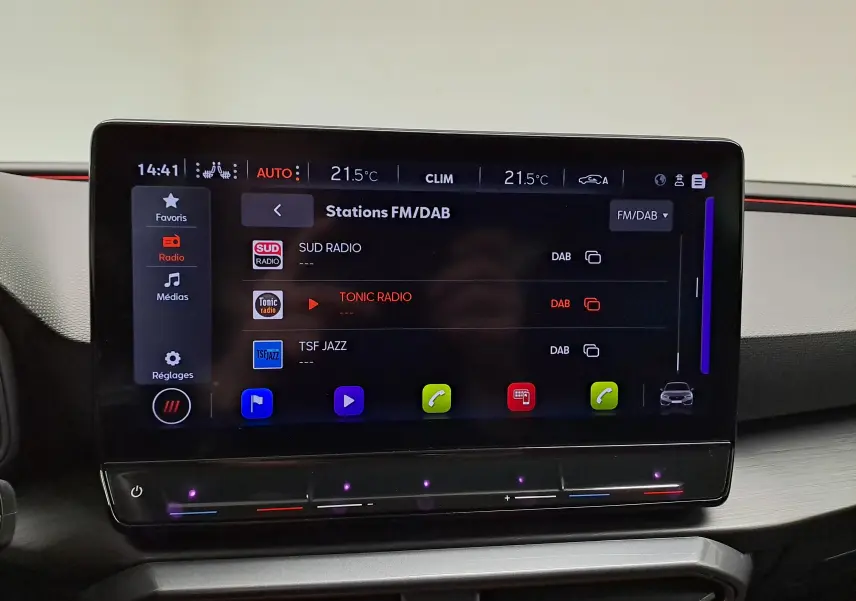 Écran tactile central du tableau de bord du CUPRA Leon 2023 affichant les stations FM/DAB avec interface moderne et commandes tactiles.