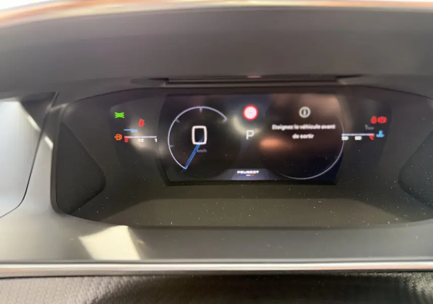 Tableau de bord numérique du Peugeot 2008 Hybrid 145ch GT 2025 affichant la vitesse à 0 km/h et un message d'alerte au centre.