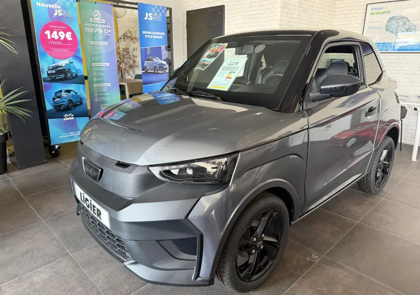 Vue 3/4 avant droite d'une Ligier JS50 Elite Revo D+ gris graphite avec toit noir et jantes noires en showroom.