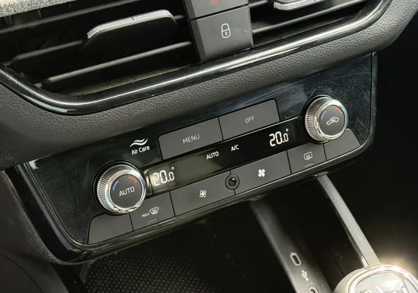 Gros plan sur la console centrale noire du Skoda Scala TSI 116, montrant la climatisation automatique bi-zone à 20°C.