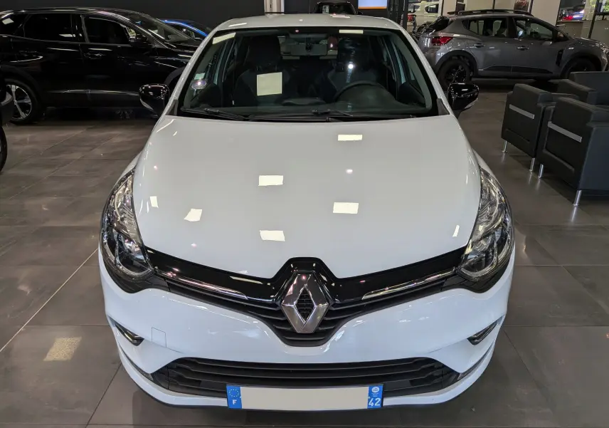Vue avant d'une Renault Clio IV TCe 75 blanche Glacier, avec calandre noire brillante et logo Renault centré.