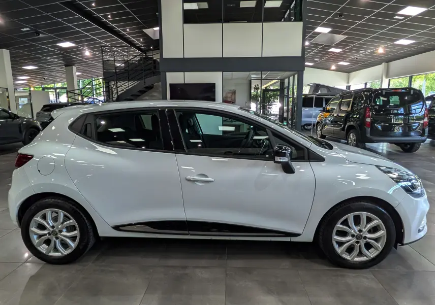 Renault Clio IV TCe 75 blanc glacier vue de profil côté gauche, avec jantes alliage et poignées de porte intégrées.