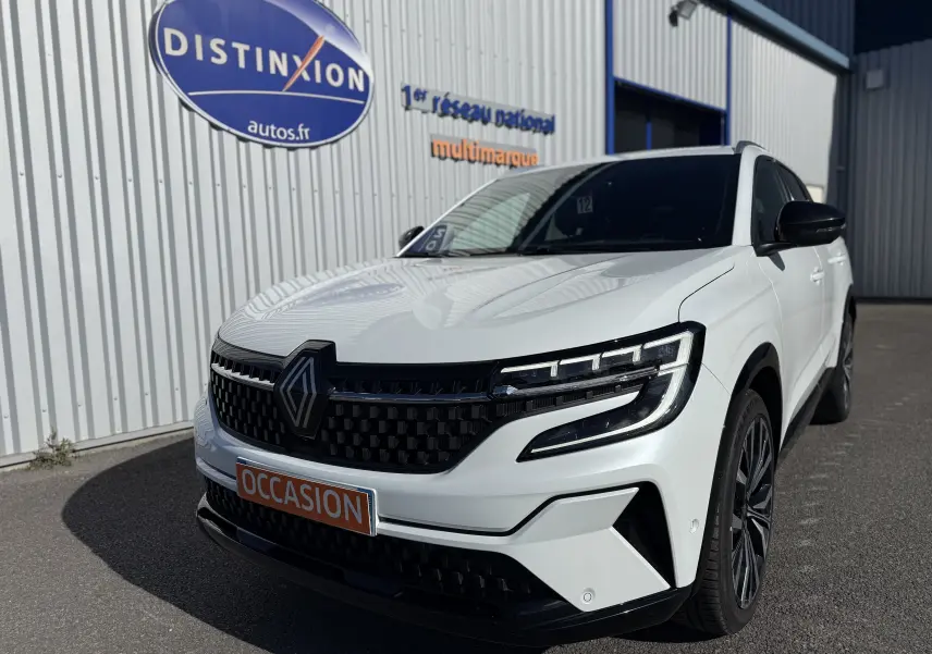 Renault Austral blanc en 3/4 avant droit, avec calandre noire à motif carré et phares LED distinctifs.