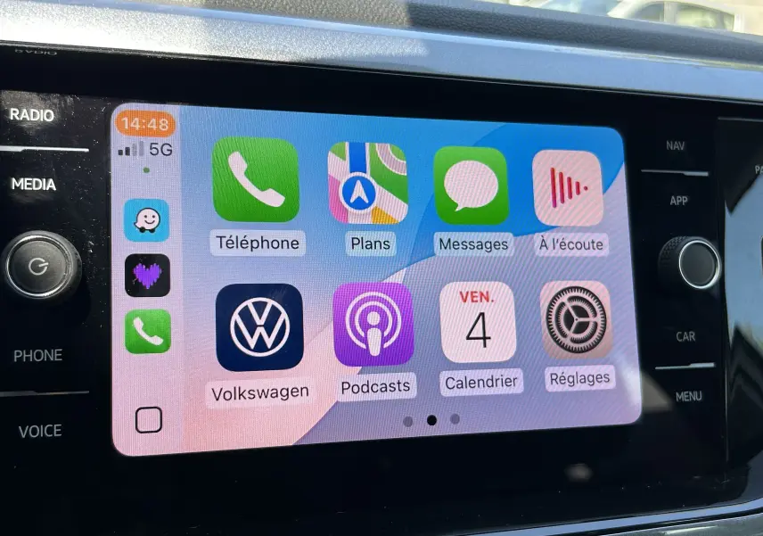 Écran tactile central du Volkswagen Taigo blanc 2022 affichant l'interface Apple CarPlay avec applications connectées.