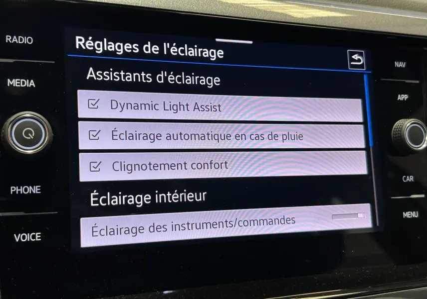 Écran tactile du système multimédia du Volkswagen Taigo blanc, affichant les réglages d'assistants d'éclairage.