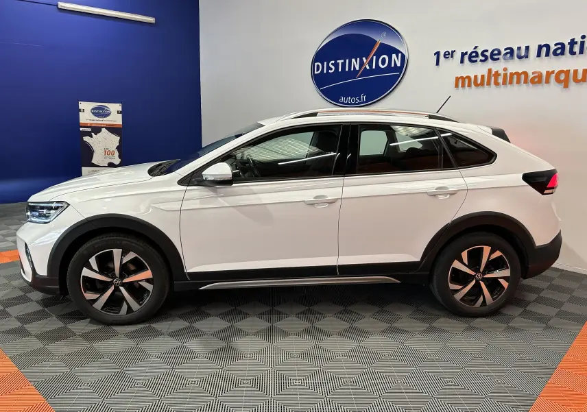 Profil côté gauche d'un Volkswagen Taigo blanc pur 2022 avec jantes alliage et détails noirs contrastants.