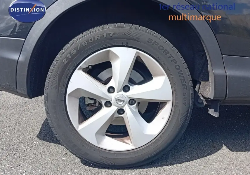 Gros plan sur la roue avant droite d'un Nissan Qashqai noir métal de 2018 avec jante argentée et pneu Sportpower SUV.