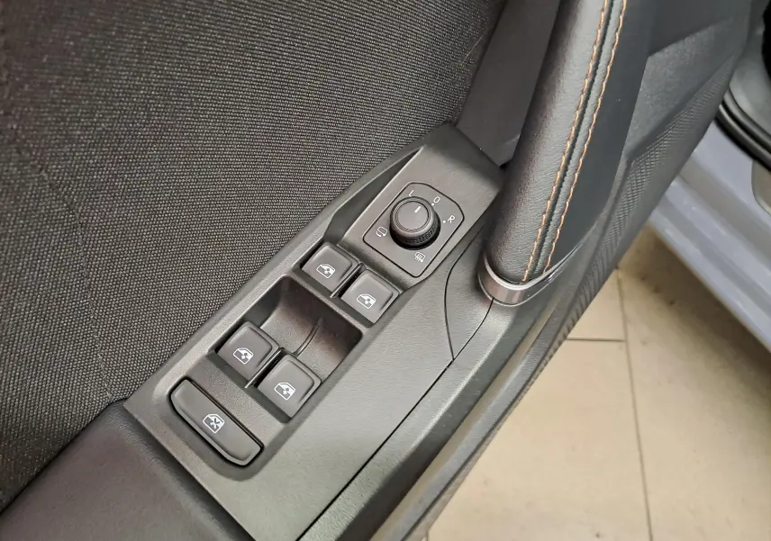 Gros plan sur les commandes des vitres et rétroviseurs côté conducteur d'une CUPRA Leon ST gris Graphène.