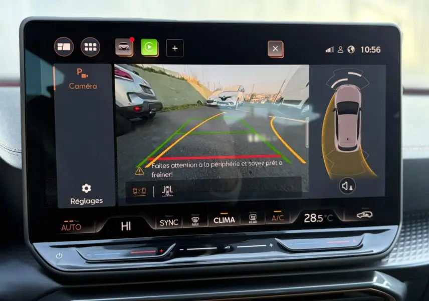 Écran tactile intérieur de la CUPRA Leon blanc montrant la caméra de recul avec aides au stationnement activées.
