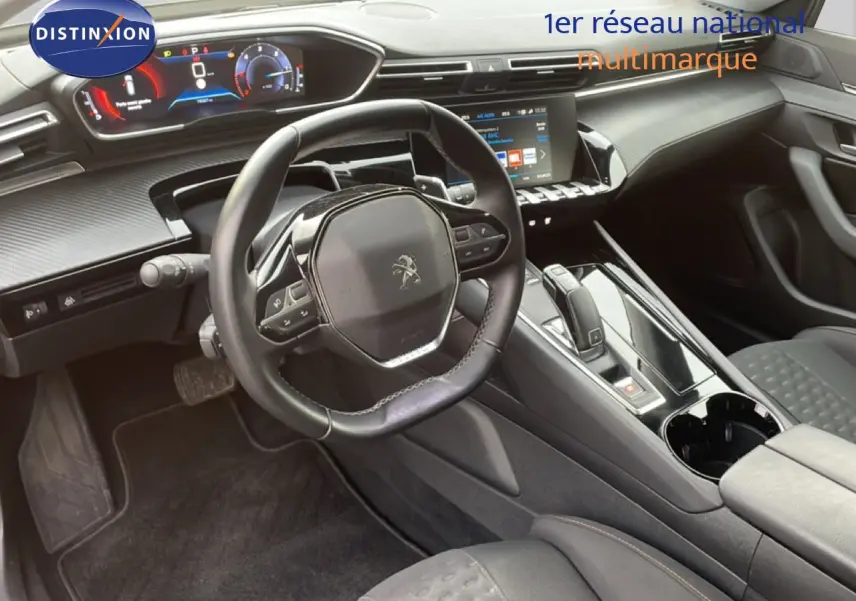 Vue intérieure du poste de conduite de la Peugeot 508 SW 2021, volant cuir noir et tableau de bord numérique.