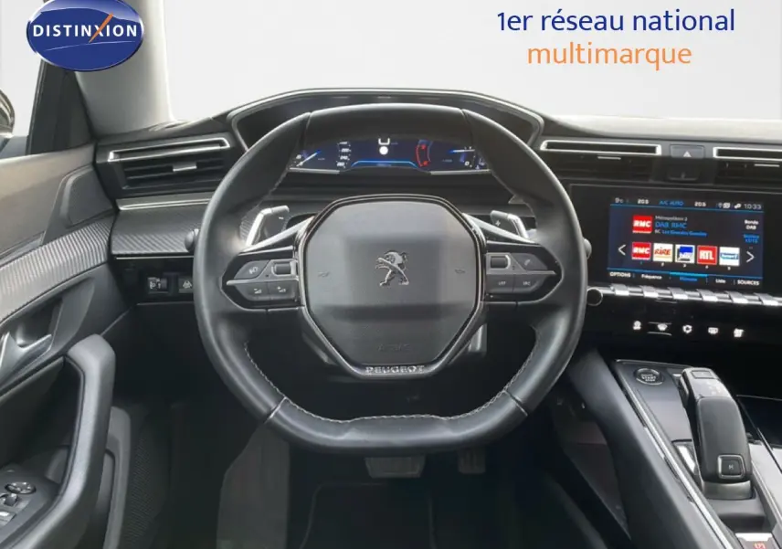 Vue centrée sur le volant cuir noir et le tableau de bord digital d'une Peugeot 508 SW 2021, intérieur moderne et connecté.