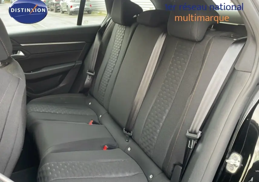 Vue intérieure sur les sièges arrière en tissu noir de la Peugeot 508 SW 2021, porte ouverte côté droit.