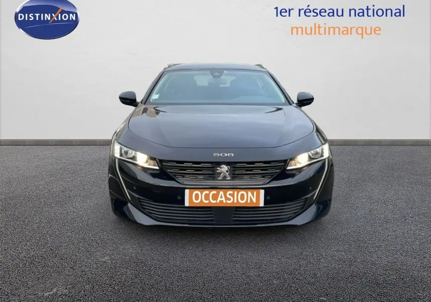 Vue avant d'une Peugeot 508 SW noire Perla Nera Metal avec phares allumés et plaque "OCCASION" visible.