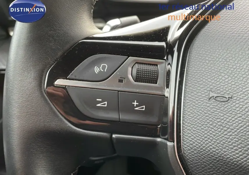 Gros plan sur les commandes gauche du volant cuir noir du Peugeot 508 SW noir Perla Nera 2021, avec boutons de volume et appel.