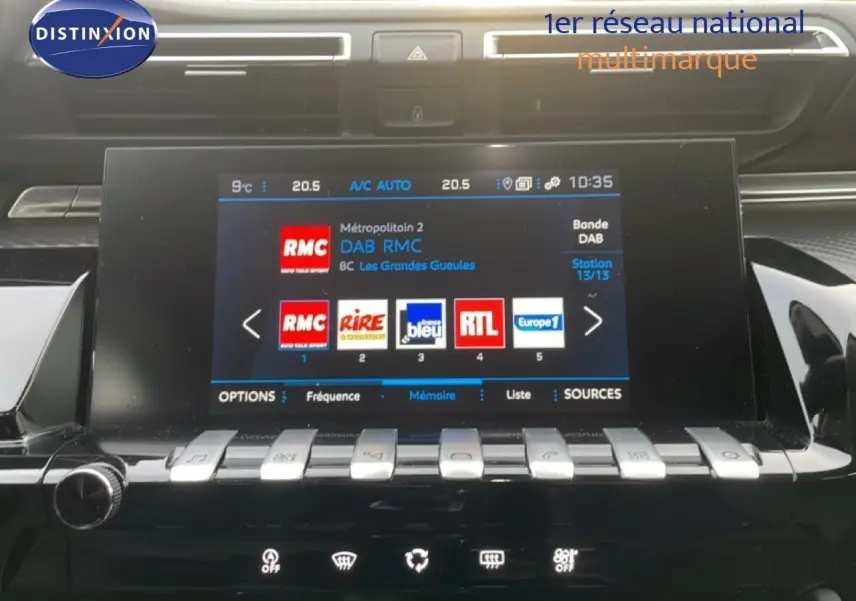 Vue rapprochée de l’écran tactile central de la Peugeot 508 SW 2021, affichant les stations radio avec finition noire brillante.