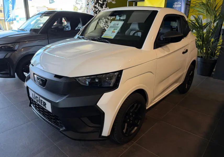 Vue 3/4 avant droite d'une Ligier JS50 Select Revo D+ blanc glacier avec détails noirs contrastants en showroom.