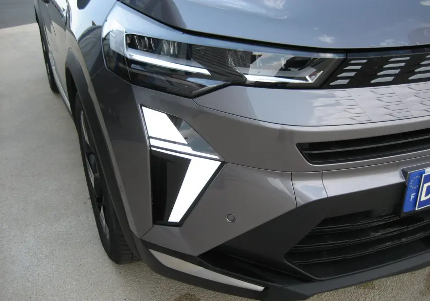 Gros plan sur l'avant droit gris cassiopée du Renault Symbioz 2025, mettant en valeur ses feux LED distinctifs et la calandre moderne.