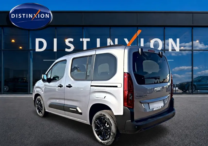 Vue 3/4 arrière droite du Citroën Berlingo Steel Grey 2026 avec jantes noires et barres de toit visibles.