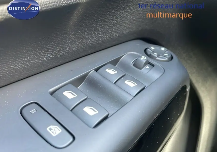 Gros plan sur les commandes des vitres électriques côté conducteur d'un Citroën C5 Aircross bleu Eclipse Metal.