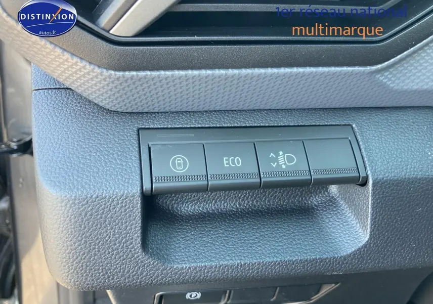 Gros plan sur les commandes ECO et réglage des phares du tableau de bord du Dacia Duster gris schiste 2026.