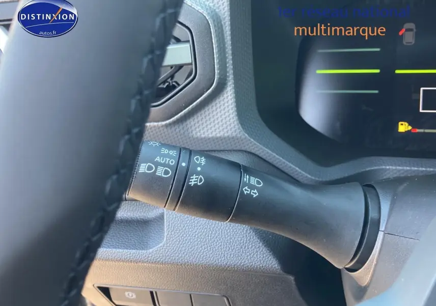Gros plan sur la commande des feux et clignotants côté gauche du tableau de bord du Dacia Duster gris schiste 2026.
